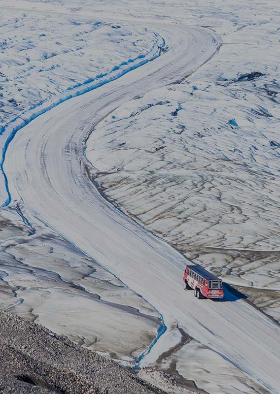 An Ice Explorer vehicle drives along an ice road on the Athabasca Glacier