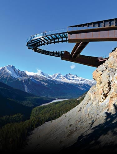 A metal and glass walkway over a deep valley.