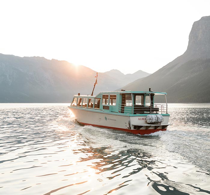 Lake Minnewanka tour boat in the water in morning
