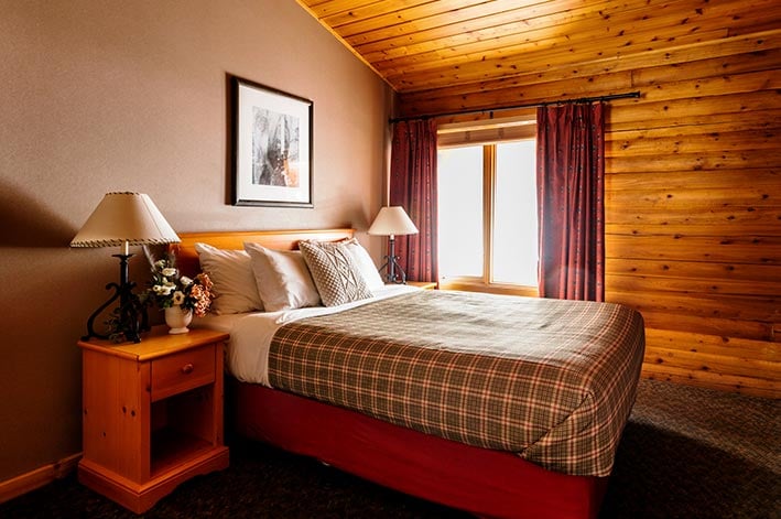 A bed in a wooden cabin room.
