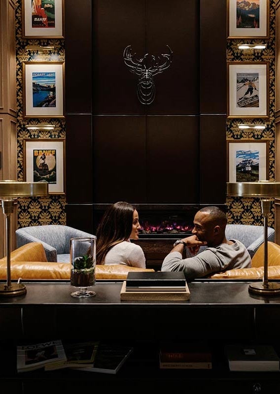 Two people sit in a leather sofa in a luxury hotel lobby