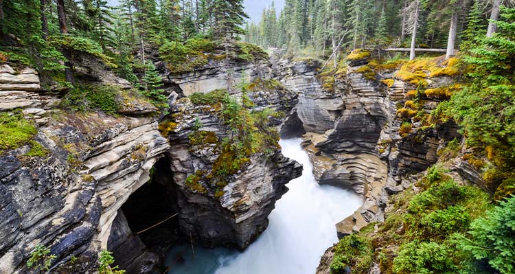 A view down a rushing river between rocky canyon walls.