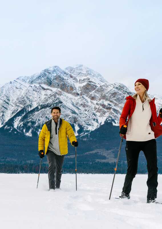 Two people cross-country-ski across a frozen lake.