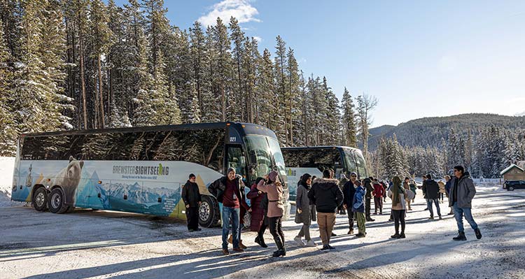 Groups of families exit a Brewster Sightseeing Bus in the winter.