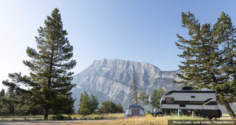 RV and tent set up at a campsite with a mountain view