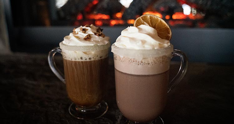 Two glass mugs of hot chocolate.