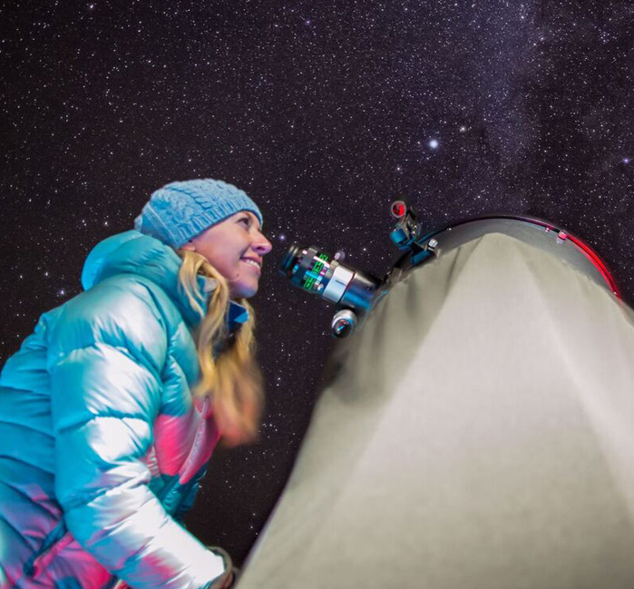 A person looking at the stars through a telescope