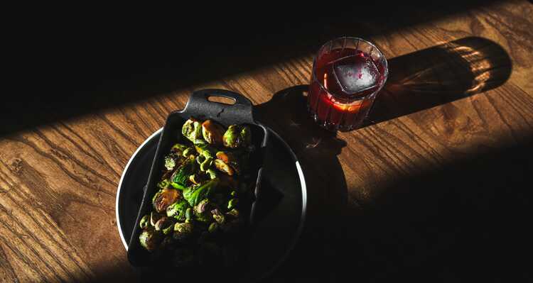 A plate of Brussels spouts and a cocktail.