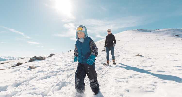 Parent and child snowshoeing on a mountain