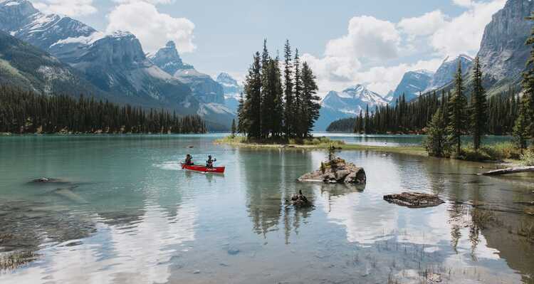 People canoeing across Maligne Lake