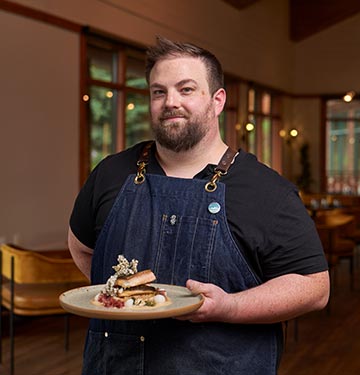 Chef Shane Rutledge poses with a dish in Aalto dining room.