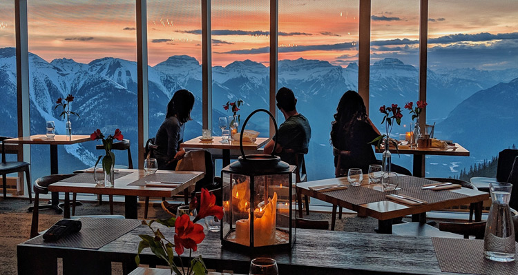 People dining at Sky Bistro and looking at the sunset and mountain view