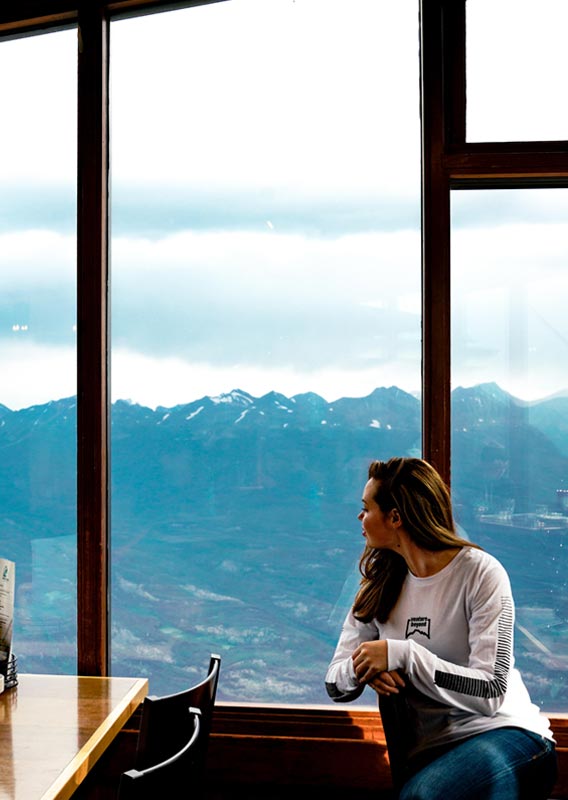 A person looking out the cafe window at the mountain view