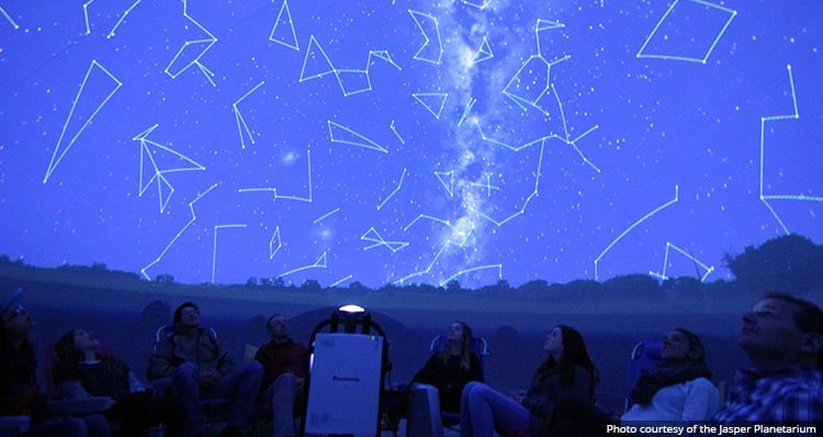 A group of people watch a planetarium show.