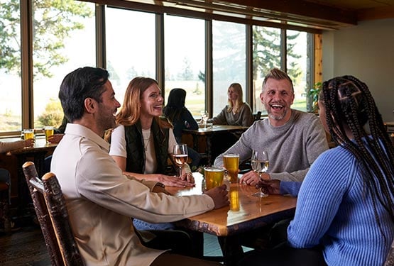 A group of people sit together at a dining table.