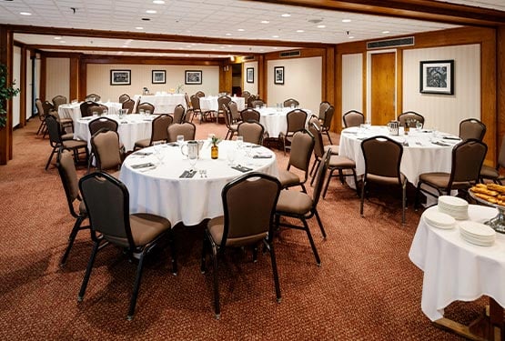 A conference room with round tables set up.