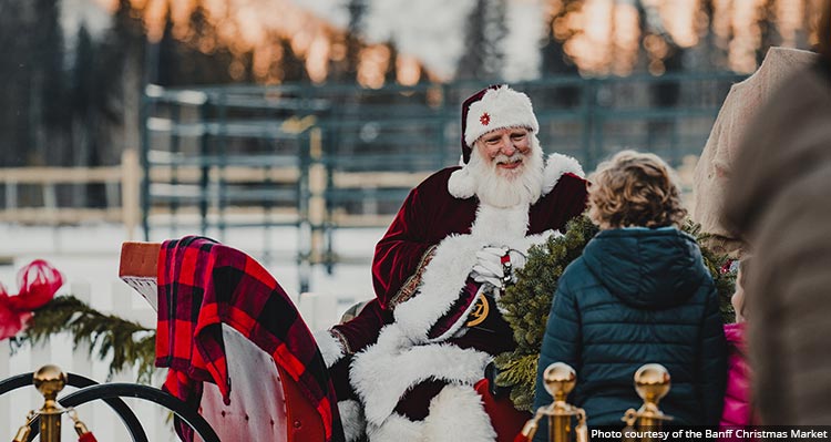 Santa Claus in a sleigh greets a child.