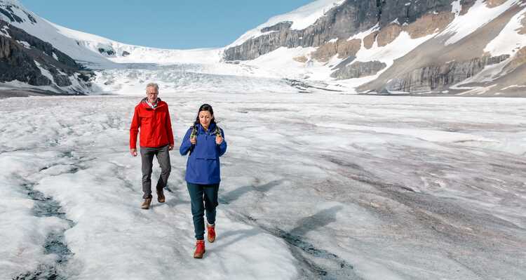 Two visitors walking along the Columbia Icefield