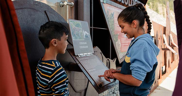 Two children read educational singage at Jasper Skywalk