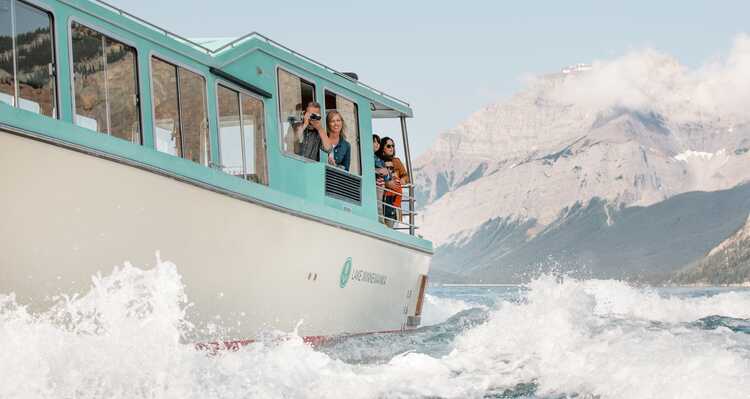 Family looking out the window at the view on Lake Minnewanka Cruise