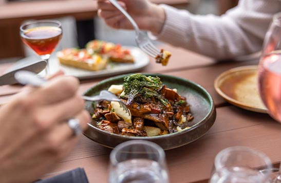 People eat from a plate of food on a table.