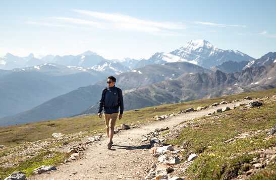 Person hiking a trail with a mountain view