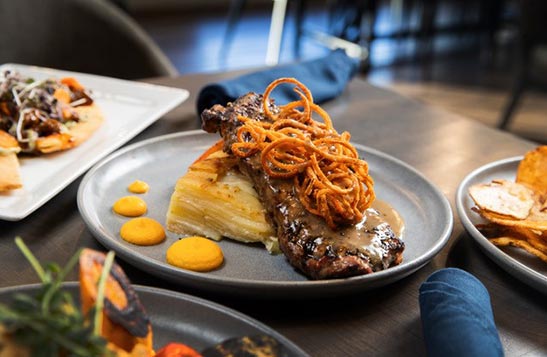 A plated steak on a restaurant tabl.e