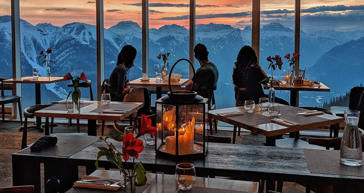 Guests at Sky Bistro watching the sunset over the mountains